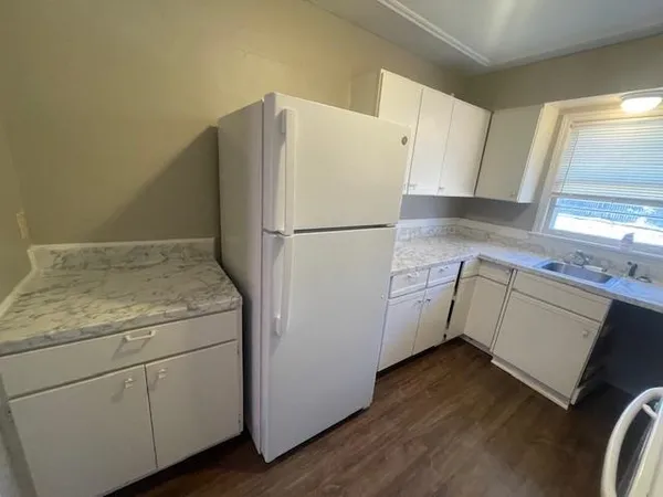 a utility room with wooden floor washer and dryer