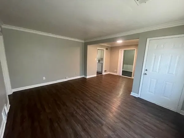 a view of an empty room with wooden floor
