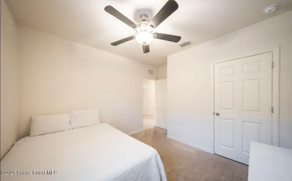 a bedroom with a large bed and a ceiling fan