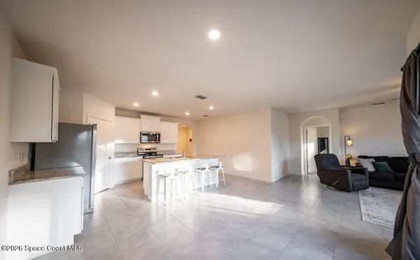 a view of kitchen with stainless steel appliances refrigerator stove microwave and cabinets