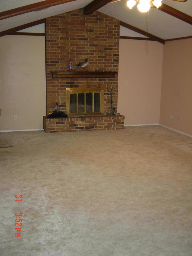 8131 Coronado Trail Amarillo, TX 79110 - Photo 11 of 12 a view of an empty room with wooden floor and a fireplace