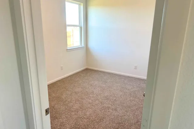 an empty room with windows and closet