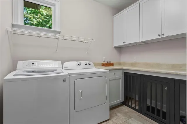 a bedroom with two beds and a large mirror next to a window