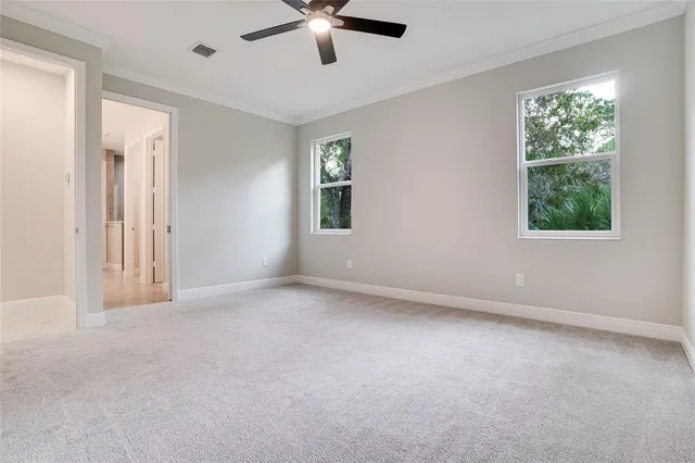 an empty room with a window and a fan