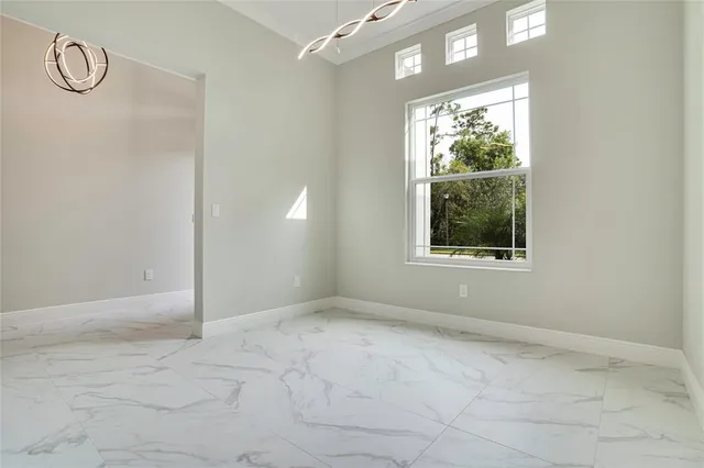 a view of an empty room with window and closet area