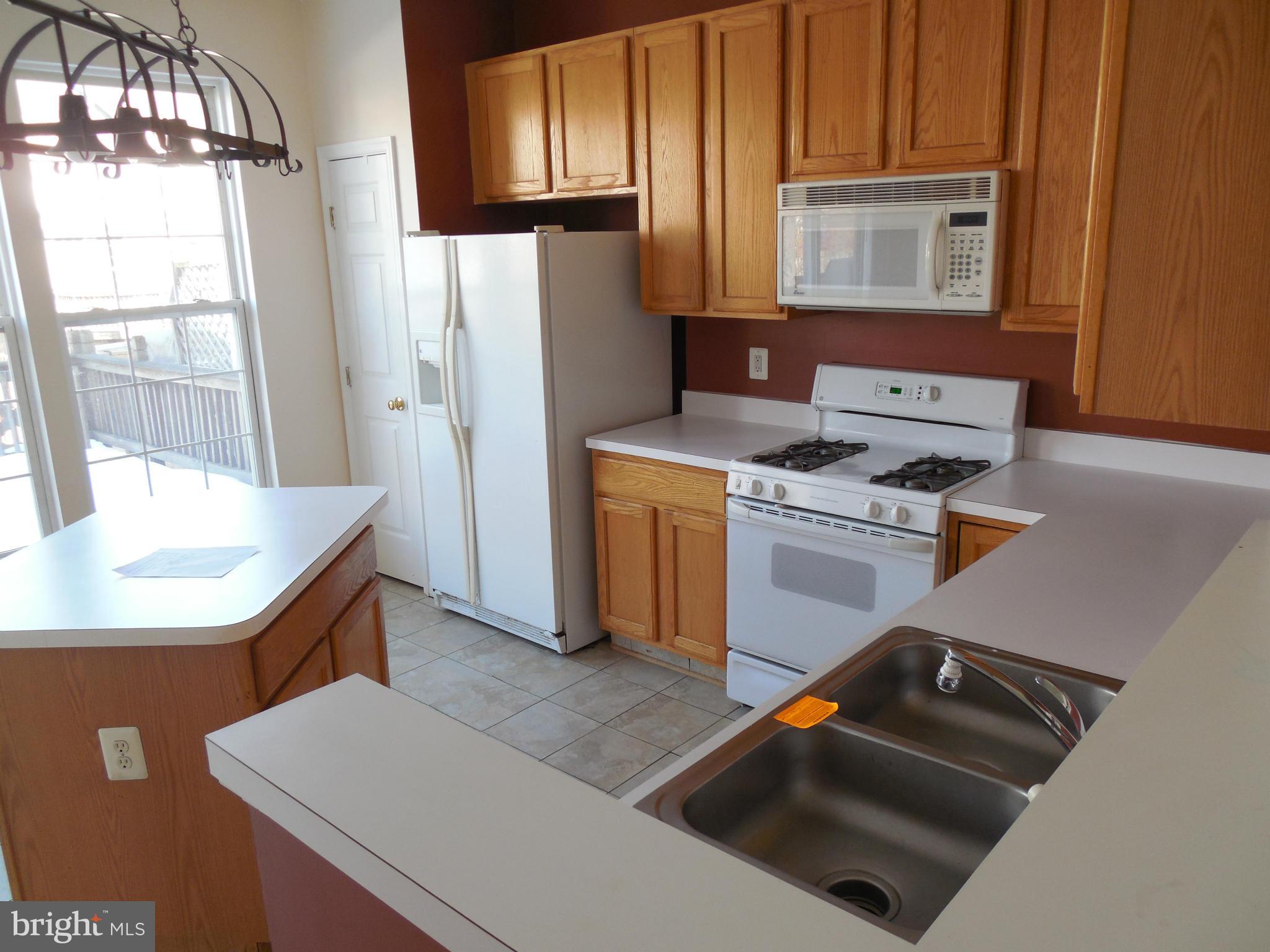 5540 Upshur Square Frederick, MD 21703 - Photo 2 of 8 a kitchen with a stove a refrigerator and a microwave