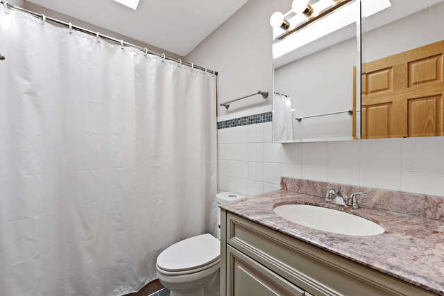 1736 Evergreen Lane Park Ridge, IL 60068 - Photo 27 of 37 a bathroom with a granite countertop sink toilet and a mirror