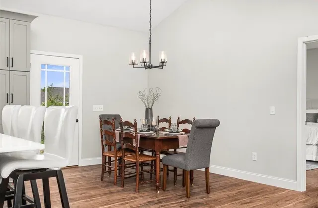 a dining room with furniture a chandelier and wooden floor