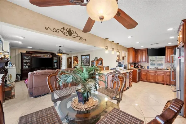 a living room with furniture kitchen view and a chandelier