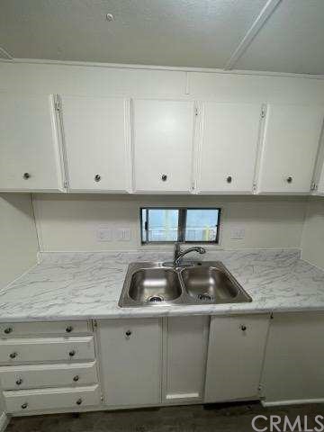 2345 190th, Unit 76 Redondo Beach, CA 90278 - Photo 4 of 10 a kitchen with granite countertop white cabinets and a sink
