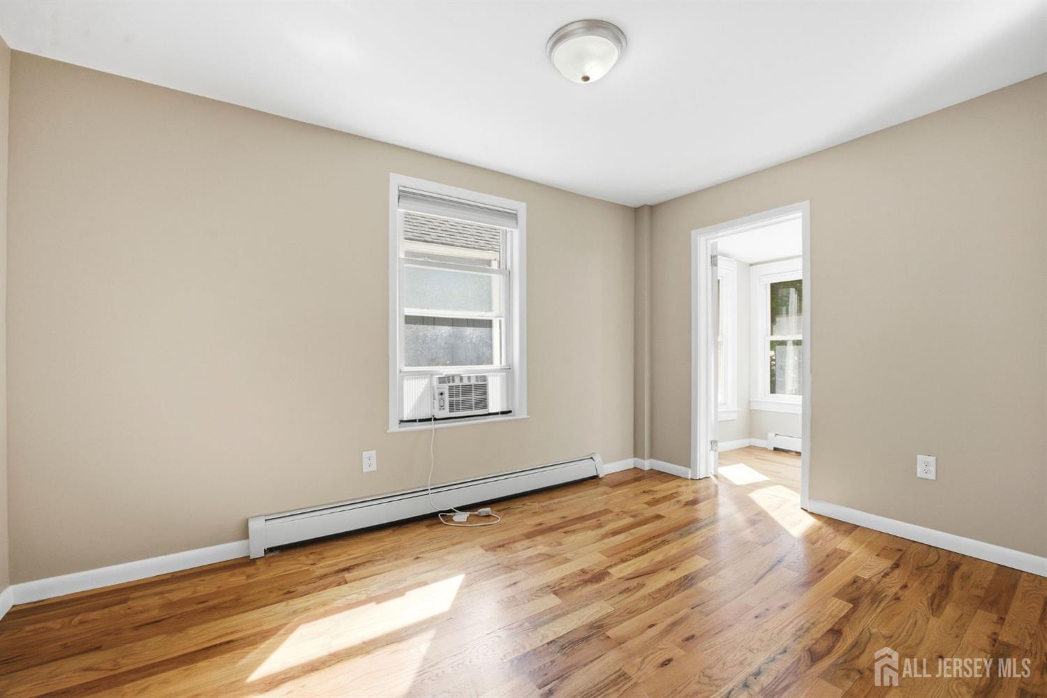 164 South Ridgewood Road, Unit 2 South Orange, NJ 07079 - Photo 12 of 19 an empty room with wooden floor and windows