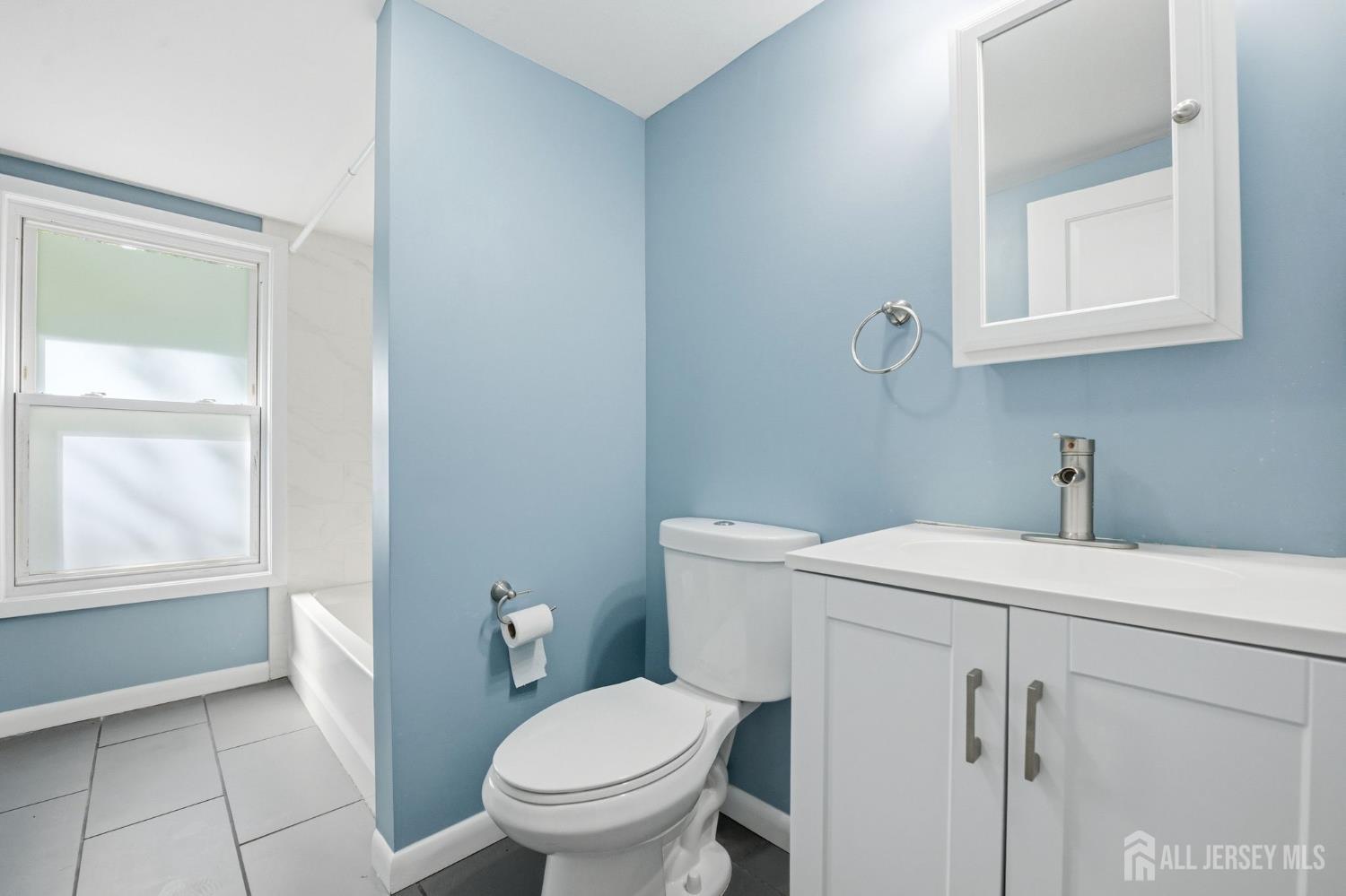 164 South Ridgewood Road, Unit 2 South Orange, NJ 07079 - Photo 17 of 19 a bathroom with a sink a toilet and a vanity