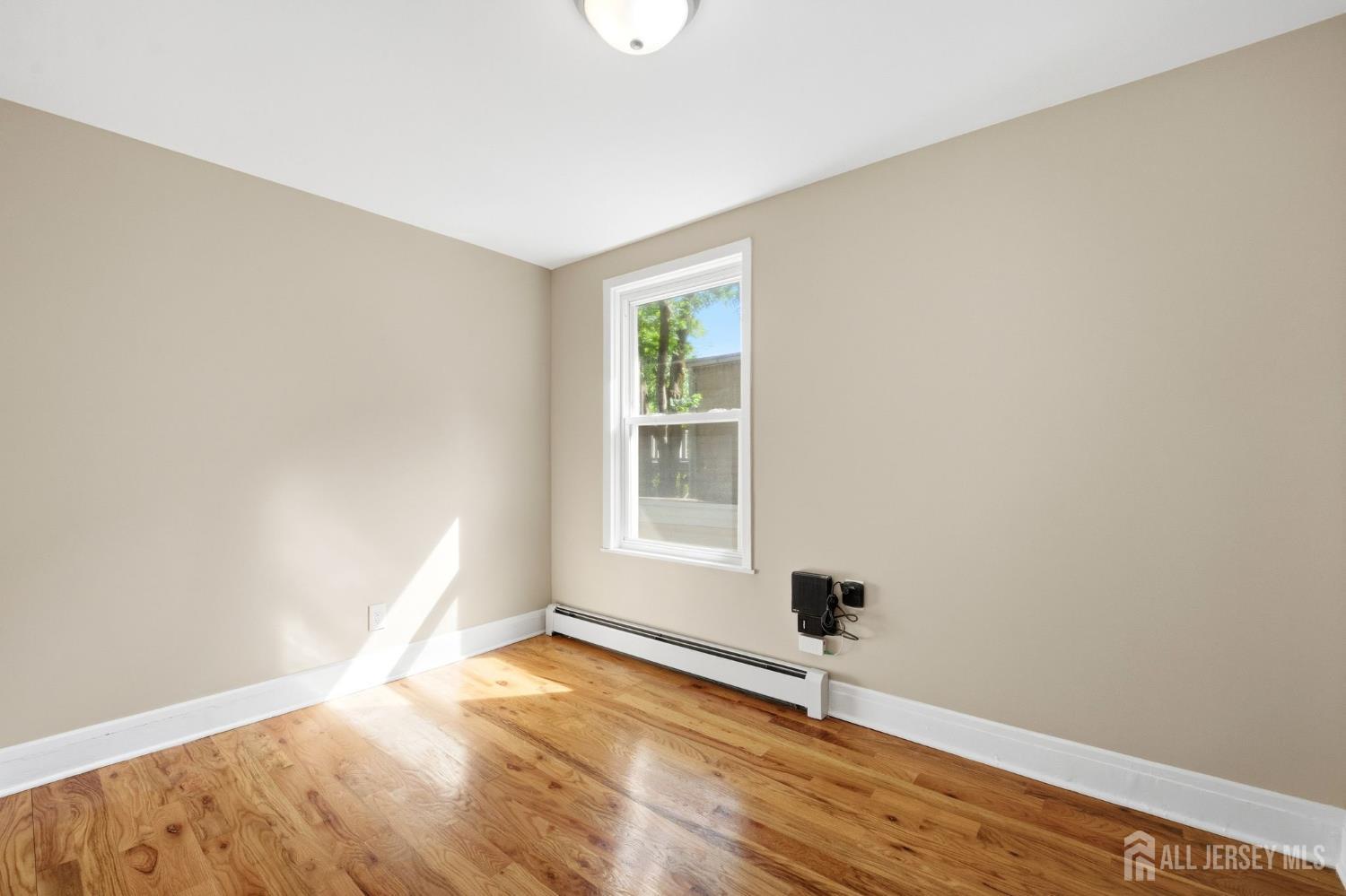 164 South Ridgewood Road, Unit 2 South Orange, NJ 07079 - Photo 10 of 19 a view of an empty room with wooden floor and a window