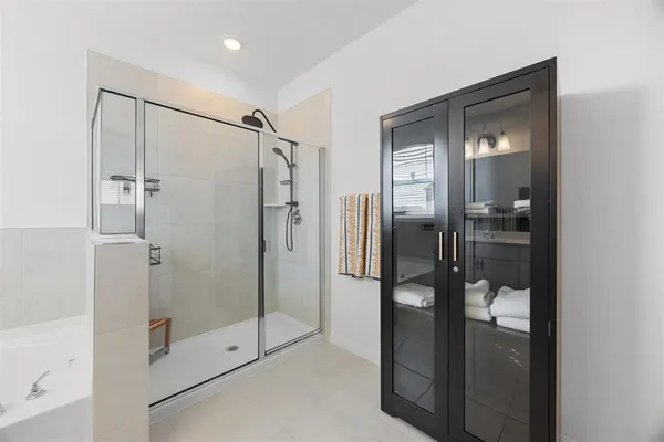 a bathroom with a glass shower door and a mirror