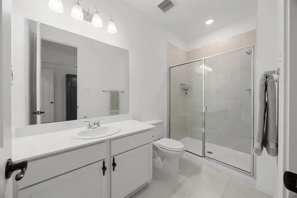 a bathroom with a shower sink mirror and toilet
