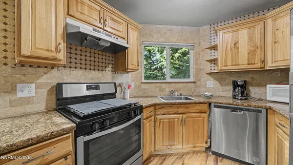 a kitchen with stainless steel appliances granite countertop a stove sink and cabinets