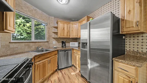 a kitchen with stainless steel appliances granite countertop a sink stove and refrigerator