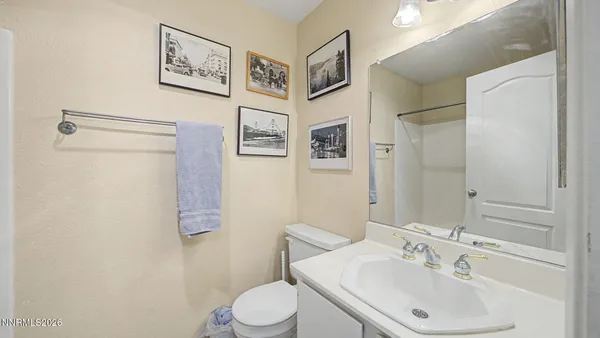 a bathroom with a sink mirror and toilet