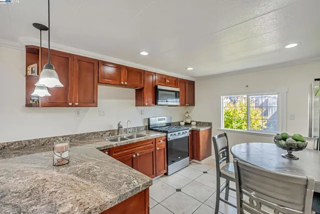 a kitchen with stainless steel appliances granite countertop a sink stove and refrigerator