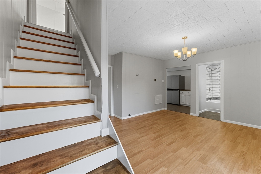 130 Broadway Fall River, MA 02721 - Photo 17 of 42 a view of a bedroom with wooden floor and staircase