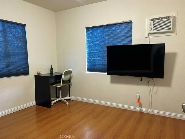 a living room with a flat screen tv a lamp and a floor to ceiling window