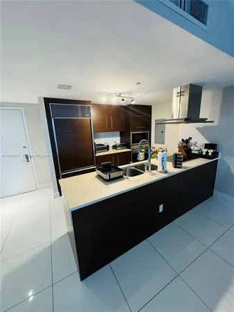 a kitchen with stainless steel appliances a sink a stove a microwave a sink a refrigerator and cabinets