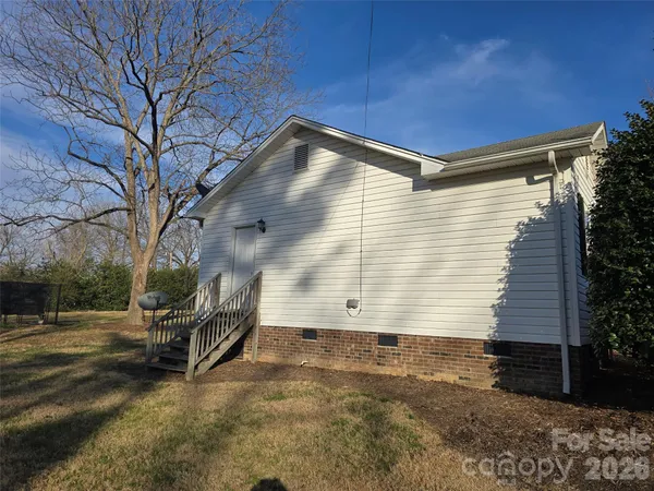 a backyard of a house with dishwasher and wooden fence