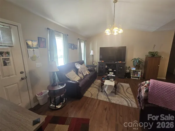 a living room with furniture a chandelier a rug and a window