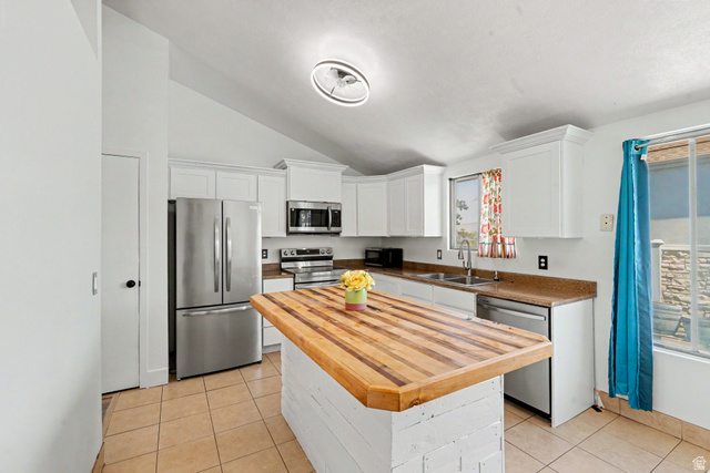 3689 Lasso Loop Circle Magna, UT 84044 - Photo 7 of 26 Kitchen featuring a custom wood-finish island, stainless steel appliances, white cabinetry, and light-toned tile flooring