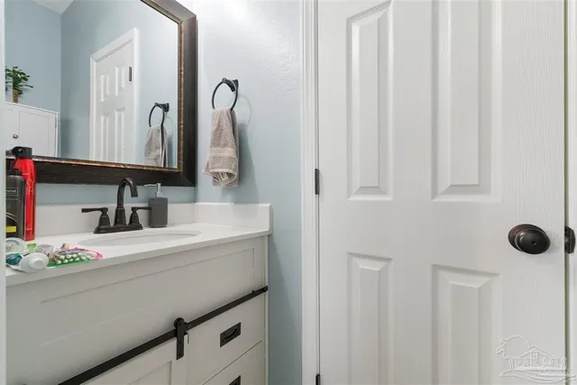a bathroom with a sink vanity and a mirror