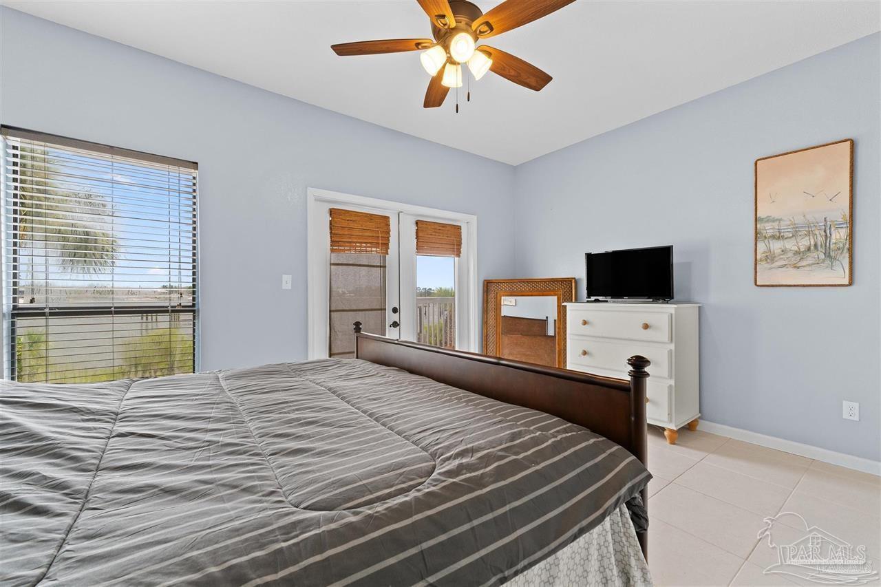 16590 Perdido Key Drive, Unit 6B Pensacola, FL 32507 - Photo 13 of 25 a bedroom with a bed and a flat screen tv