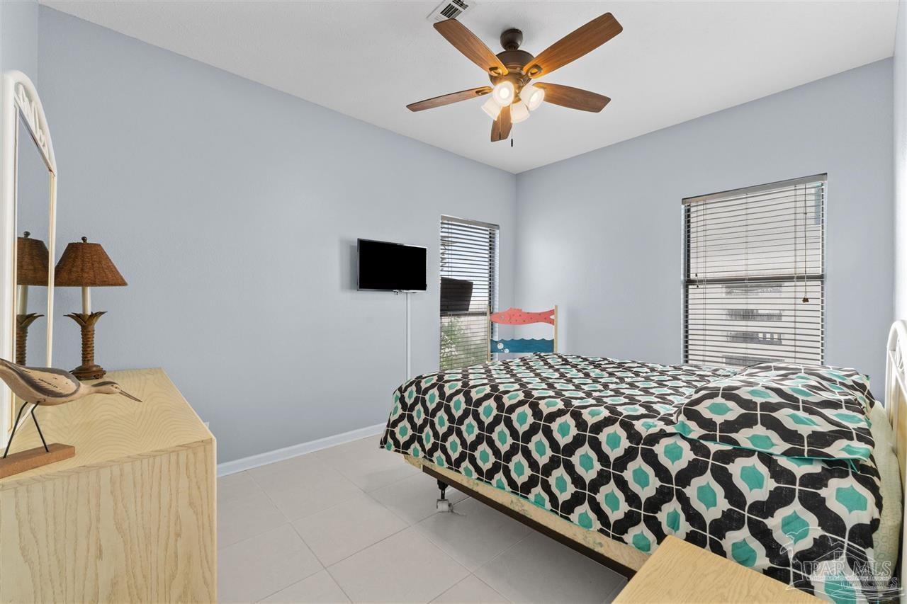 16590 Perdido Key Drive, Unit 6B Pensacola, FL 32507 - Photo 21 of 25 a bedroom with a bed and a chandelier