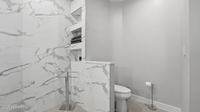 a bathroom with a toilet and a shower