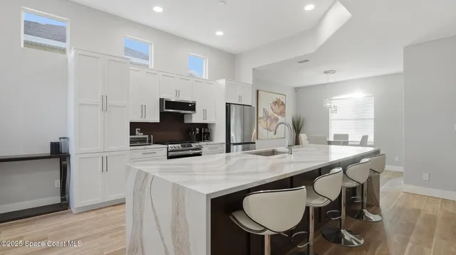 a kitchen with a dining table chairs and refrigerator