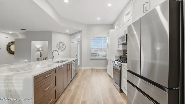 a kitchen with kitchen island granite countertop appliances cabinets and a sink
