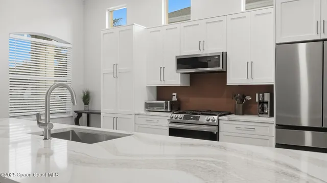 a kitchen with stainless steel appliances granite countertop a refrigerator and a stove top oven