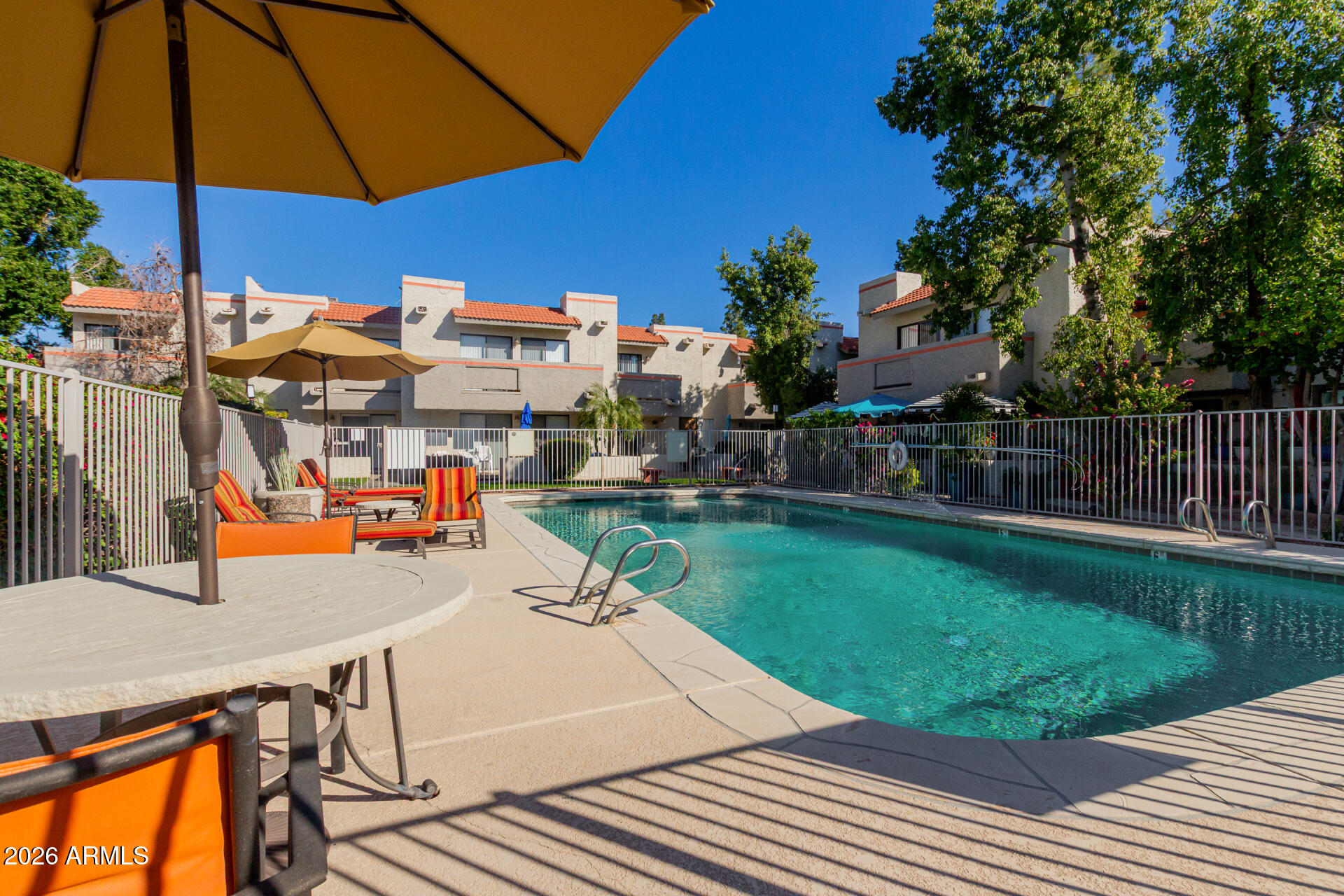 885 North Granite Reef Road, Unit 82 Scottsdale, AZ 85257 - Photo 28 of 32 a view of a patio with a table and chairs under an umbrella