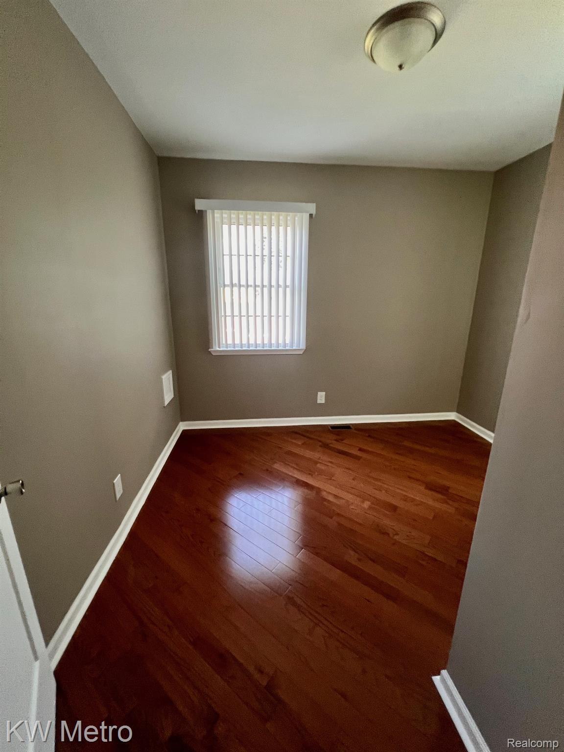 939 Webb Street Detroit, MI 48202 - Photo 14 of 19 Room featuring wood-finish flooring, neutral wall paint, white baseboards, and a window with vertical blinds