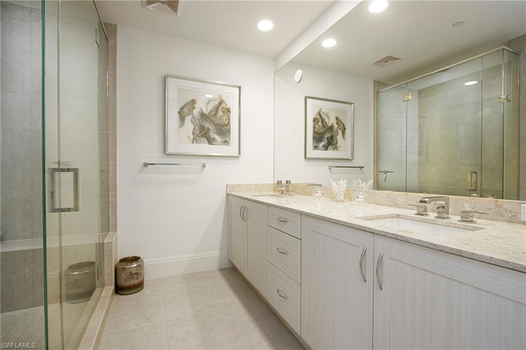1035 3rd Avenue South, Unit 303 Naples, FL 34102 - Photo 13 of 26 a bathroom with a double vanity sink and a mirror