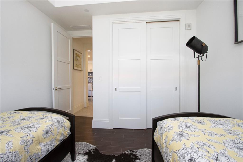 1035 3rd Avenue South, Unit 303 Naples, FL 34102 - Photo 15 of 26 a bedroom with a bed and a dresser
