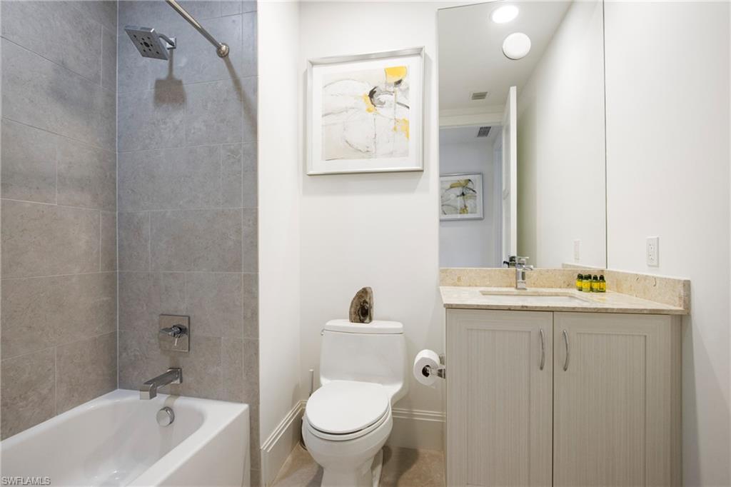 1035 3rd Avenue South, Unit 303 Naples, FL 34102 - Photo 16 of 26 a bathroom with a toilet sink and mirror