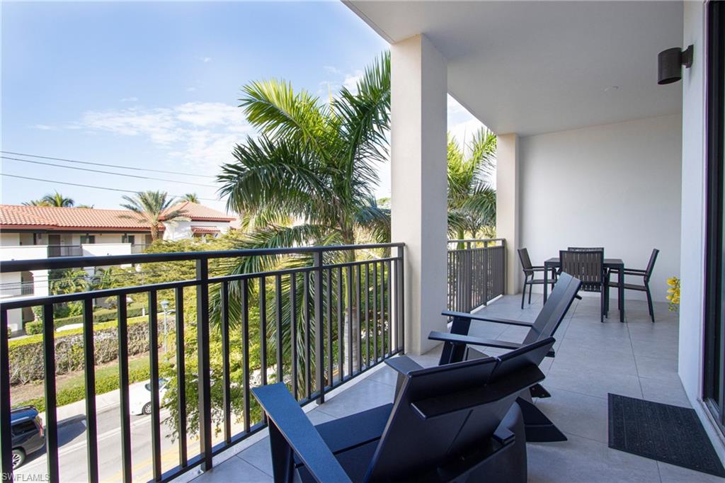 1035 3rd Avenue South, Unit 303 Naples, FL 34102 - Photo 19 of 26 a view of a balcony with chairs and wooden floor
