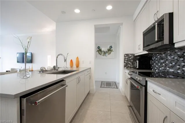 a kitchen with stainless steel appliances granite countertop a sink and stove top oven