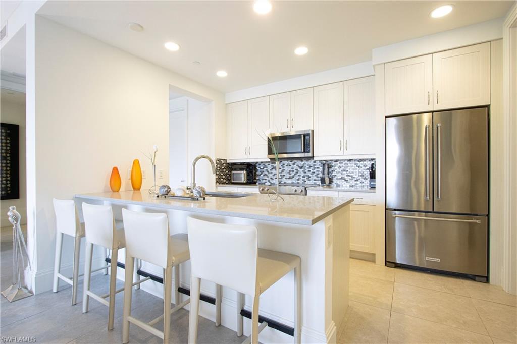 1035 3rd Avenue South, Unit 303 Naples, FL 34102 - Photo 9 of 26 a kitchen with stainless steel appliances granite countertop a refrigerator and a stove top oven