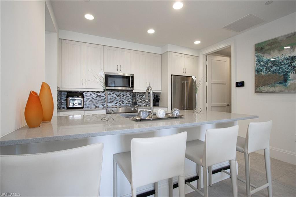 1035 3rd Avenue South, Unit 303 Naples, FL 34102 - Photo 10 of 26 a kitchen with stainless steel appliances granite countertop a sink and a stove