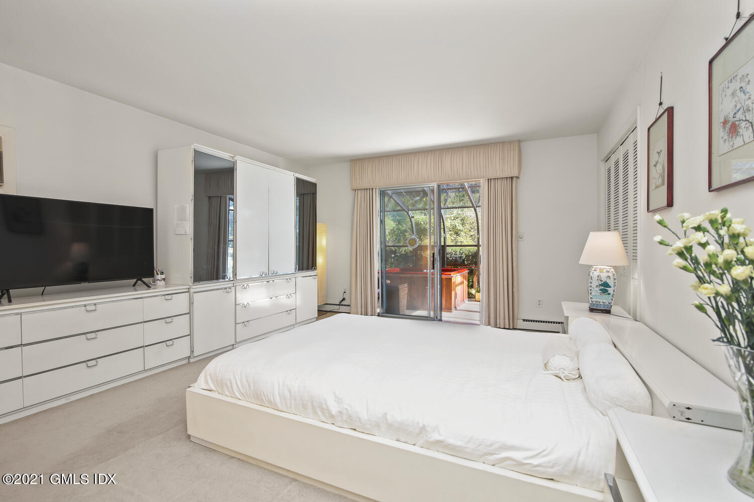 387 Stanwich Road Greenwich, CT 06830 - Photo 21 of 50 a spacious bedroom with a large bed and a flat screen tv