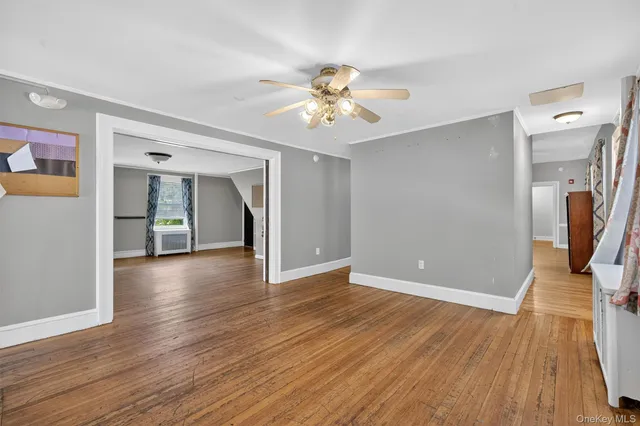 a view of a livingroom with wooden floor and a ceiling fan