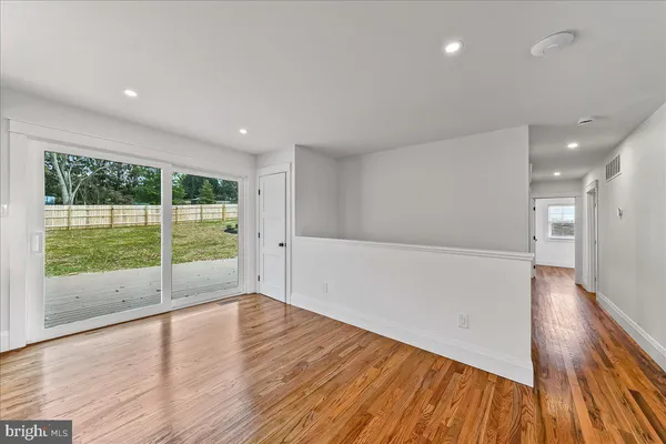 an empty room with windows and ceiling fan