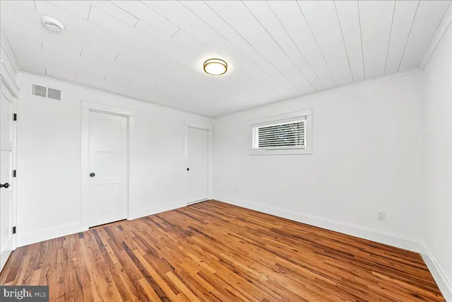 a view of a room with wooden floor and window
