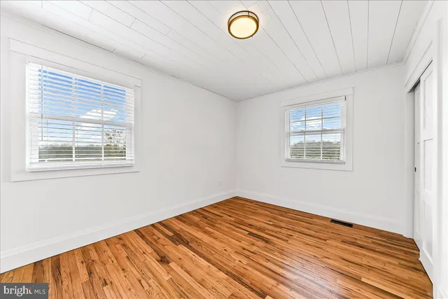 a view of a room with wooden floor and white walls